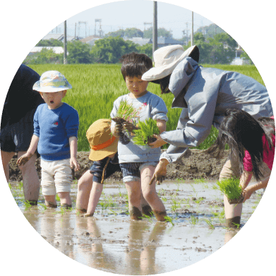 写真：地域の方が子どもと田植えする様子